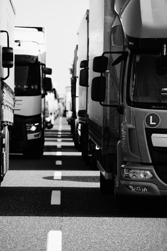 A row of trucks stuck in a traffic jam on a road